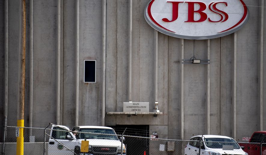 FILE - In this April 8, 2020, file photo, a truck bearing Weld County insignia sits outside the administrative office entrance at JBS USA in Greeley, Colo. A major meatpacking plant in Colorado that was closed because of the coronavirus is set to reopen Friday, April 24, 2020, after disinfecting the facility over the last two weeks, even as some question how workers will be able to maintain social distancing to curb the spread of the disease. The plant in Greeley was closed April 11 after health officials in Weld County cited the close proximity of workers to each other and employees working while they were sick as factors in the outbreak. (Alex McIntyre/The Greeley Tribune via AP, File)