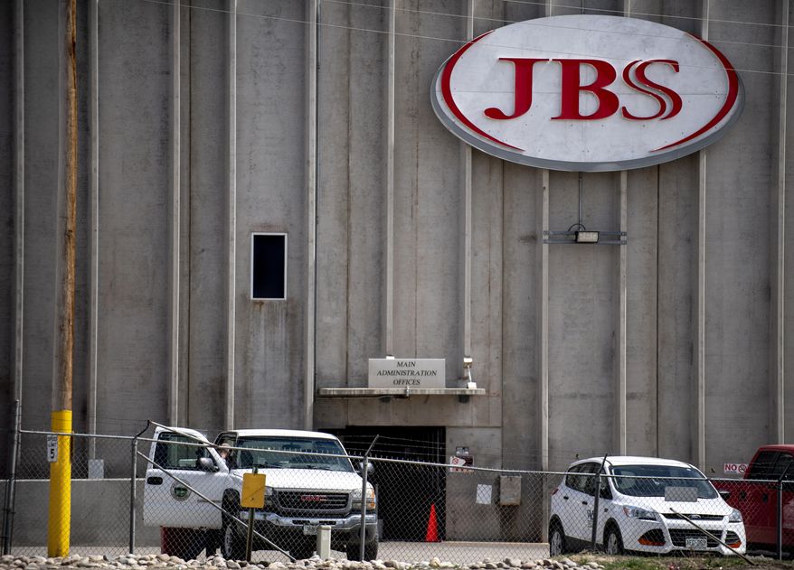 FILE - In this April 8, 2020, file photo, a truck bearing Weld County insignia sits outside the administrative office entrance at JBS USA in Greeley, Colo. A major meatpacking plant in Colorado that was closed because of the coronavirus is set to reopen Friday, April 24, 2020, after disinfecting the facility over the last two weeks, even as some question how workers will be able to maintain social distancing to curb the spread of the disease. The plant in Greeley was closed April 11 after health officials in Weld County cited the close proximity of workers to each other and employees working while they were sick as factors in the outbreak. (Alex McIntyre/The Greeley Tribune via AP, File)