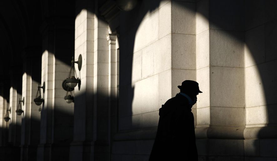 FILE - In this April 15, 2020, file photo a man wears a face mask to protect against the spread of the new coronavirus at Union Station in Washington. A quarter of Americans say their household suffered a job loss from the coronavirus outbreak, but a majority still feel positive about their personal finances, according to a new poll from The Associated Press-NORC Center for Public Affairs Research. (AP Photo/Patrick Semansky, File)