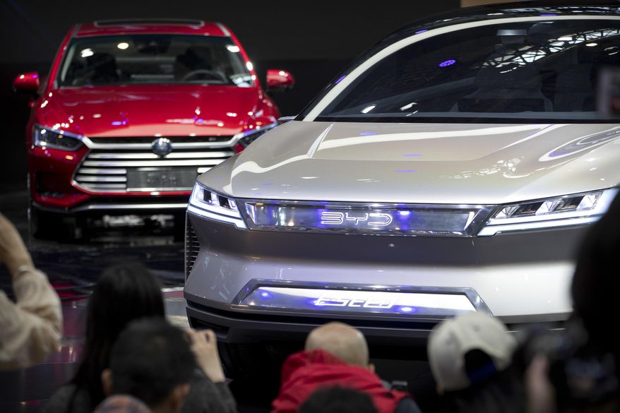 In this April 25, 2018, photo, attendees take photos of the E-SEED electric concept car during a press conference by Chinese automaker BYD at the China Auto Show in Beijing. China is promising more subsidies to shore up plunging electric car sales amid the coronavirus pandemic but set limits that exclude Tesla’s made-in-China model. Subsidies and tax breaks that were due to end this year will be extended by two years in response to “an accumulation of unfavorable factors” including the virus, the Finance Ministry said Thursday, April 23, 2020. (AP Photo/Mark Schiefelbein) **FILE**