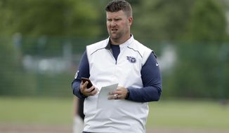 FILE - In this June 12, 2019, file photo, Tennessee Titans general manager Jon Robinson watches players during an organized team activity at the Titans&#39; NFL football training facility in Nashville, Tenn. The 2020 NFL Draft is April 23-25.(AP Photo/Mark Humphrey, File)