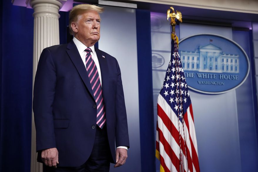 President Donald Trump listens as Vice President Mike Pence speaks about the coronavirus in the James Brady Press Briefing Room of the White House, Friday, April 24, 2020, in Washington. (AP Photo/Alex Brandon)
