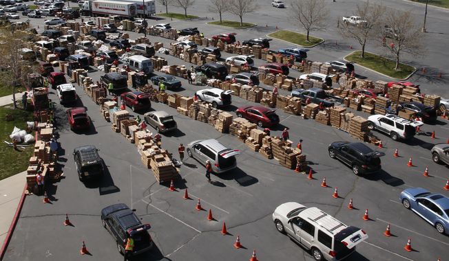 Cars line up for food at the Utah Food Bank's mobile food pantry at the Maverik Center Friday, April 24, 2020, in West Valley City, Utah. As coronavirus concerns continue, the need for assistance has increased, particularly at the Utah Food Bank. (AP Photo/Rick Bowmer)