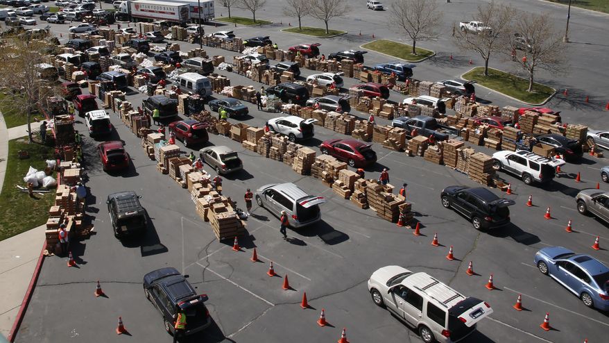 Cars line up for food at the Utah Food Bank's mobile food pantry at the Maverik Center Friday, April 24, 2020, in West Valley City, Utah. As coronavirus concerns continue, the need for assistance has increased, particularly at the Utah Food Bank. (AP Photo/Rick Bowmer)