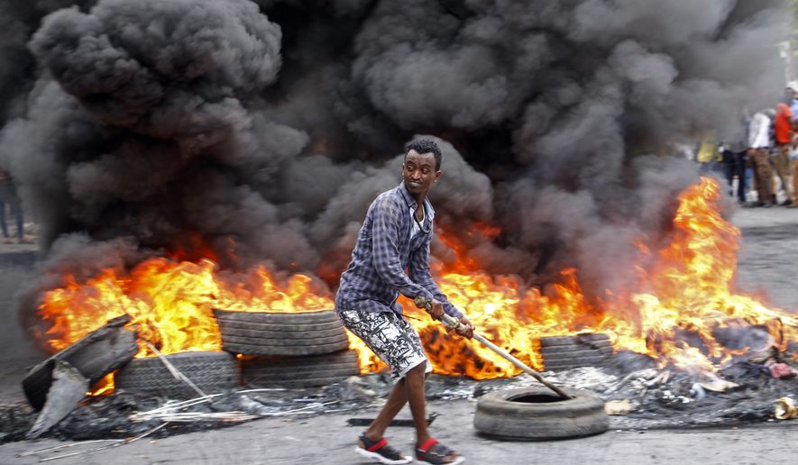 A Somali man protests against the killing Friday night of at least one civilian during the overnight curfew, which is intended to curb the spread of the new coronavirus, on a street in the capital Mogadishu, Somalia Saturday, April 25, 2020. A police officer in Somalia&#39;s capital has been arrested in the fatal shooting of at least one civilian while enforcing coronavirus restrictions, a fellow police officer said, sparking protests that continued Saturday with crowds of angry young men burning tires and demanding justice. (AP Photo/Farah Abdi Warsameh)