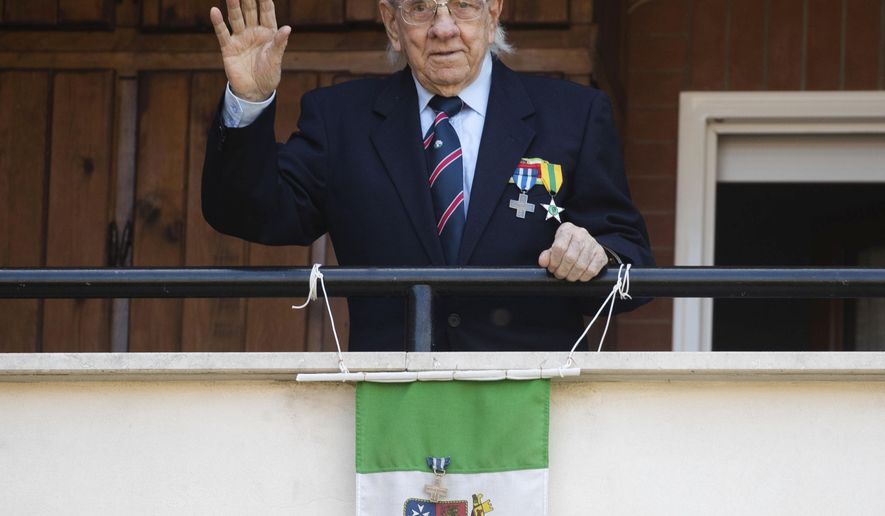 Former partisan Rodolfo Lai, 92, nicknamed Rudy, waves from his balcony in Rome, Thursday, April 23, 2020. On April 25 every year Italy celebrates the end of the Nazi occupation during WWII. The date is also the occasion for the members of the National Association of Italian Partisans to celebrate their uprising against the fascist rule of dictator Benito Mussolini, backed up by the Nazis, with marches throughout the country. The COVID-19 outbreak in Italy this year forced the cancellation of all the activities to celebrate the 75th anniversary of the Italian Liberation Day. (AP Photo/Alessandra Tarantino)