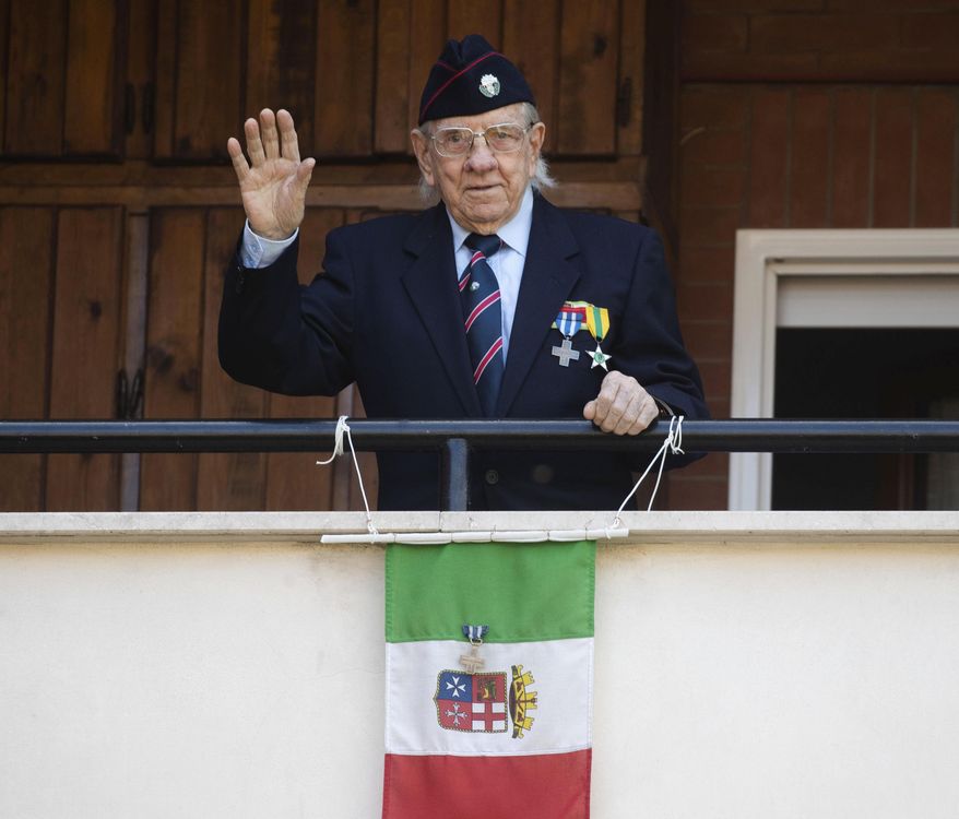 Former partisan Rodolfo Lai, 92, nicknamed Rudy, waves from his balcony in Rome, Thursday, April 23, 2020. On April 25 every year Italy celebrates the end of the Nazi occupation during WWII. The date is also the occasion for the members of the National Association of Italian Partisans to celebrate their uprising against the fascist rule of dictator Benito Mussolini, backed up by the Nazis, with marches throughout the country. The COVID-19 outbreak in Italy this year forced the cancellation of all the activities to celebrate the 75th anniversary of the Italian Liberation Day. (AP Photo/Alessandra Tarantino)