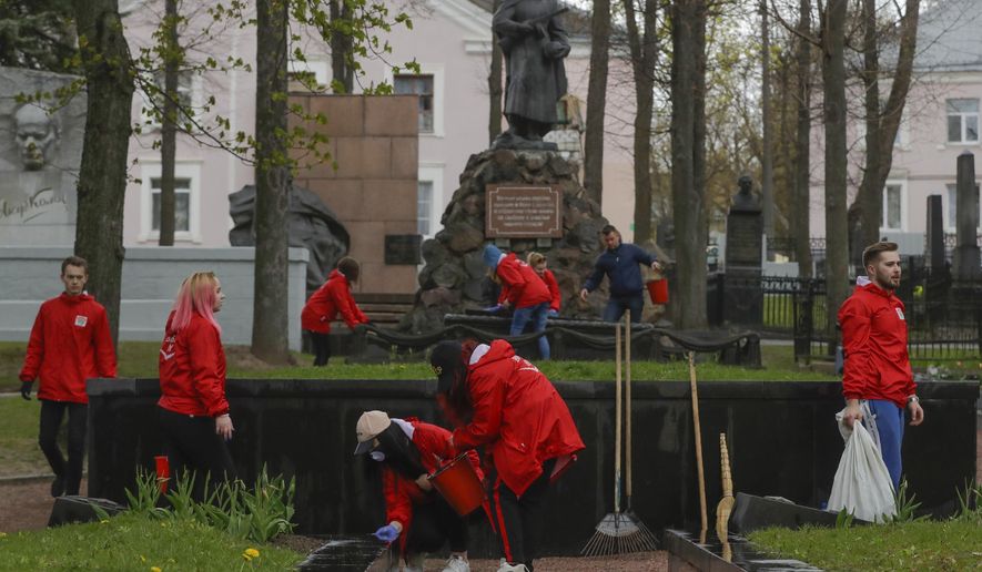 Members of the pro-government Belarussian Patriotic Union of Youth clean monuments on a military cemetery during a subbotnik, a Soviet-style Clean-up Day, in Minsk, Belarus, Saturday, April 25, 2020. Hundreds of thousands of state employees attend a mass community clean-up event on Saturday. The World Health Organization is urging the government of Belarus to cancel public events and implement measures to ensure physical and social distancing amid the growing coronavirus outbreak. (AP Photo/Sergei Grits)
