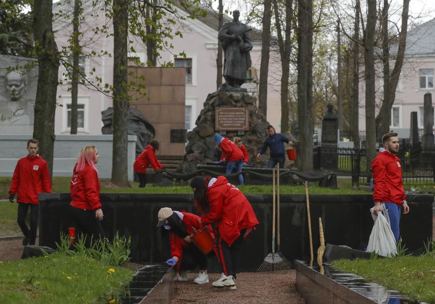 Members of the pro-government Belarussian Patriotic Union of Youth clean monuments on a military cemetery during a subbotnik, a Soviet-style Clean-up Day, in Minsk, Belarus, Saturday, April 25, 2020. Hundreds of thousands of state employees attend a mass community clean-up event on Saturday. The World Health Organization is urging the government of Belarus to cancel public events and implement measures to ensure physical and social distancing amid the growing coronavirus outbreak. (AP Photo/Sergei Grits)