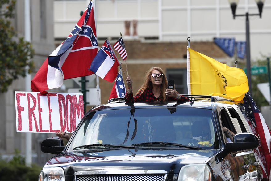 Joy Redwine calls out for reopening of the state as hers was one of dozens of vehicles, filled with protesters, that circled the Governor's Mansion in Jackson, Miss., honking their horns for over an hour to express their dissatisfaction at the gradual relaxation of the social and business social distancing restrictions established by Republican Gov. Tate Reeves, Saturday, April 25, 2020. The restrictions have been credited by Reeves for limiting the spread of COVID-19 in the state. (AP Photo/Rogelio V. Solis)