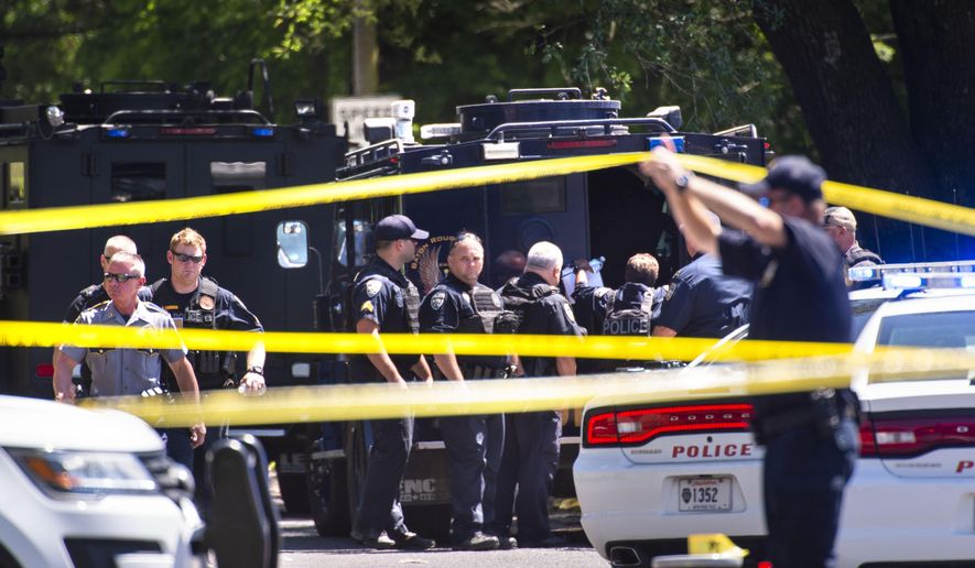 Baton Rouge Police Department officers gather at the site of a shooting in Baton Rouge, La., Sunday, April 26, 2020. The shooting has left one police officer dead and a wounded colleague fighting for life, authorities said, adding a suspect was in custody after an hourslong standoff at a home. Baton Rouge Police Chief Murphy Paul told The Advocate the officers were shot in the northern part of the city, and one of the officers later died. (Travis Spradling/The Advocate via AP)
