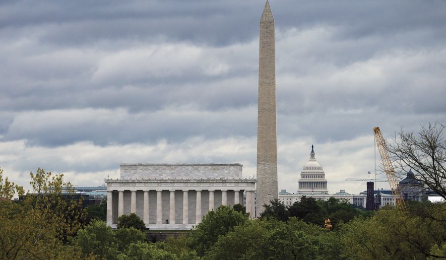 The Washington skyline is seen under gray skies Monday, April 27, 2020, during the second month of the COVID-19 pandemic. From left are the Lincoln Memorial, the Washington Monument, and the U.S. Capitol. (AP Photo/J. Scott Applewhite)