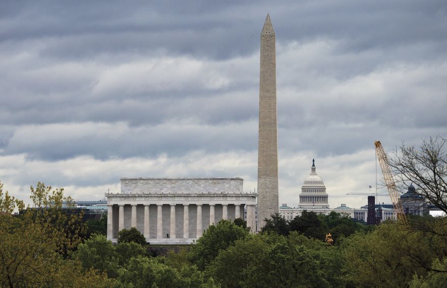 The Washington skyline is seen under gray skies Monday, April 27, 2020, during the second month of the COVID-19 pandemic. From left are the Lincoln Memorial, the Washington Monument, and the U.S. Capitol. (AP Photo/J. Scott Applewhite)