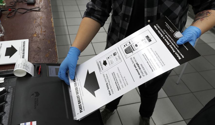 In this March 17, 2020, file photo a poll worker at the Su Nueva Lavanderia polling place uses rubber gloves as she enters a ballot in the ballot box in Chicago. A new poll from The Associated Press-NORC Center for Public Affairs Research finds Democrats are now much more likely than Republicans to support their state conducting elections exclusively by mail, 47% to 29%. (AP Photo/Charles Rex Arbogast, File)