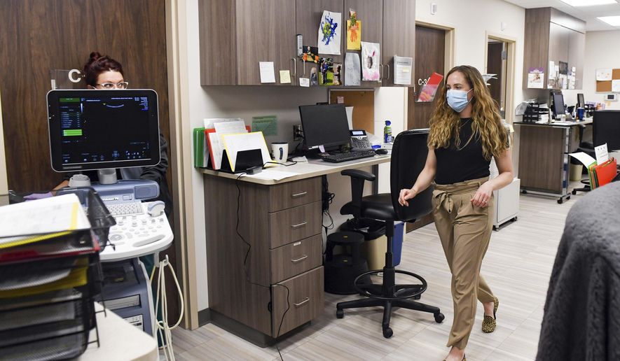 Catherine Brockmeier, OB-GYN, walks through the office to visit a patient on Wednesday, April 22, 2020 at the Avera Family Health Center in Sioux Falls. Brockmeier delivered a record 16 babies last week. (Erin Bormett/The Argus Leader via AP)