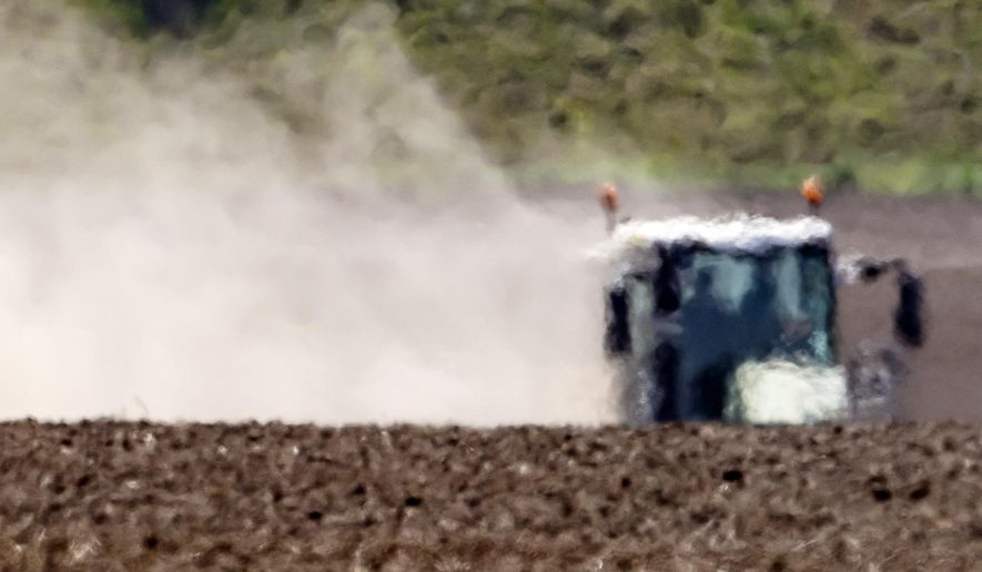 The hot air shimmers in front of a tractor during a long time of drought near Bad Lauchstaedt, Germany, Monday, April 27, 2020. (AP Photo/Jens Meyer)