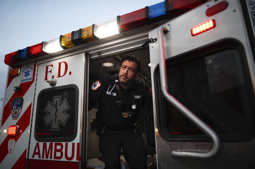 In this April 23, 2020, photo FDNY paramedic Alex Tull, who has recently recovered from COVID-19, prepares to begin his shift outside EMS station 26, the "Tinhouse", in the Bronx borough of New York. (AP Photo/John Minchillo)