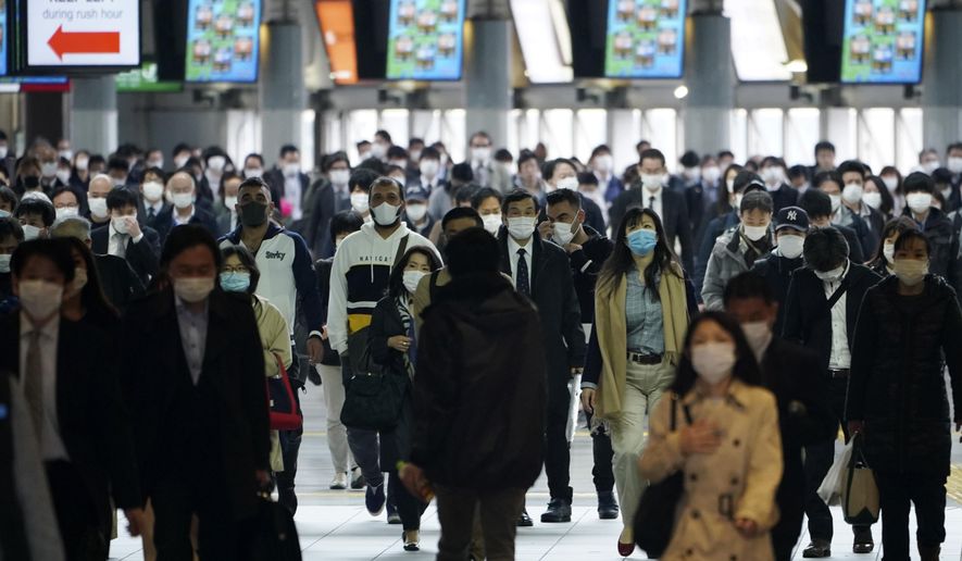 A station passageway is crowded with commuters wearing face mask during a rush hour in Tokyo Monday, April 27, 2020. Japan's Prime Minister Shinzo Abe expanded a state of emergency to all of Japan from just Tokyo and other urban areas as the virus continues to spread. (AP Photo/Eugene Hoshiko)