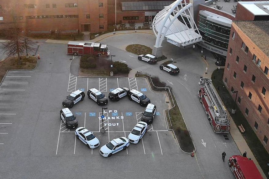 This Sunday, April 26, 2020, photo released by the Laconia Police Department on its Facebook page shows squad cars arranged in the shape of a heart in the parking lot of Lakes Region General Hospital in Laconia, N.H. The department created the display to show support and appreciation for the hospital's healthcare workers and staff the during the coronavirus pandemic. (Laconia Police Department via AP)
