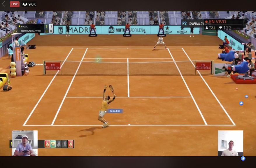 A screen grab taken on Monday April 27, 2020 showing Spain's Rafael Nadal, bottom left, playing against Canada's Denis Shapovalov, bottom right, in a "virtual" tennis match at a tournament hosted by the Madrid Open. Tennis has joined the video game craze taking over the sports world during the coronavirus pandemic, with Rafael Nadal, Andy Murray and 30 other pros trading in their rackets for controllers this week to participate in a "virtual" tournament hosted by the Madrid Open. (Mutua Madrid Open via AP)