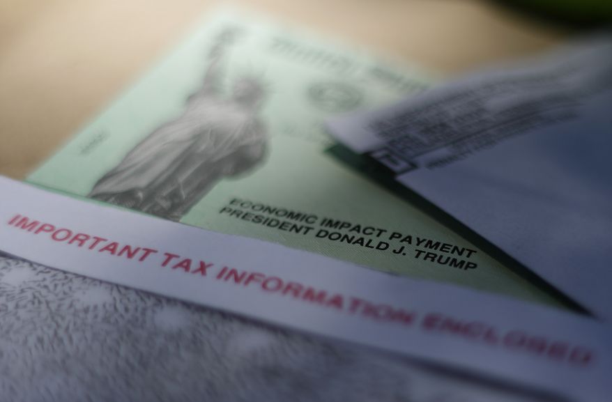 FILE - This April 23, 2020, file photo shows President Donald J. Trump's name printed on a stimulus check issued by the IRS to help combat the adverse economic effects of the new coronavirus outbreak in San Antonio. The Mexican American Legal Defense and Educational Fund is suing the federal government over its denial of federal coronavirus relief payments to U.S. citizens who are married to immigrants without social security numbers. (AP Photo/Eric Gay, File)