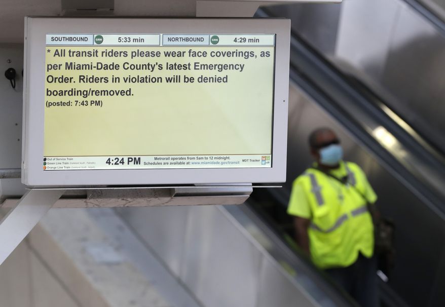 A man goes down an escalator near a monitor advising passengers to wear face coverings, Tuesday, April 28, 2020, in downtown Miami. The Transport Workers Union of America filed a lawsuit against Miami-Dade County Transportation &amp; Public Works Director Alice Bravo on April 17, citing the lack of safety and protection of workers and passengers from the new coronavirus. (AP Photo/Wilfredo Lee)