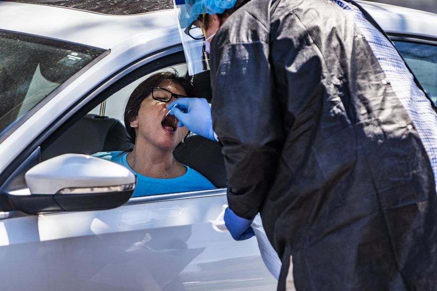 Alma Lopez gets tested for the coronavirus in a drive-thru setting at the People&#39;s Center Clinics &amp;amp; Services in Minneapolis on Monday, April 27, 2020. (Richard Tsong-Taatarii/Star Tribune via AP)