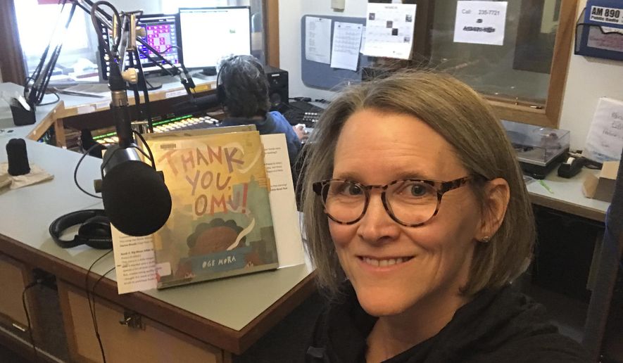 In this April 2, 2020, photo provided by librarian Claudia Haines, she poses for the selfie while preparing to read stories on the air at local radio station KBBI in Homer, Alaska. The library teamed up with the station to continue its popular story hour for preschoolers after it closed to the public amid coronavirus concerns. It's among ways the nation's libraries are dealing with closures amid coronavirus concerns. (Claudia Haines via AP)