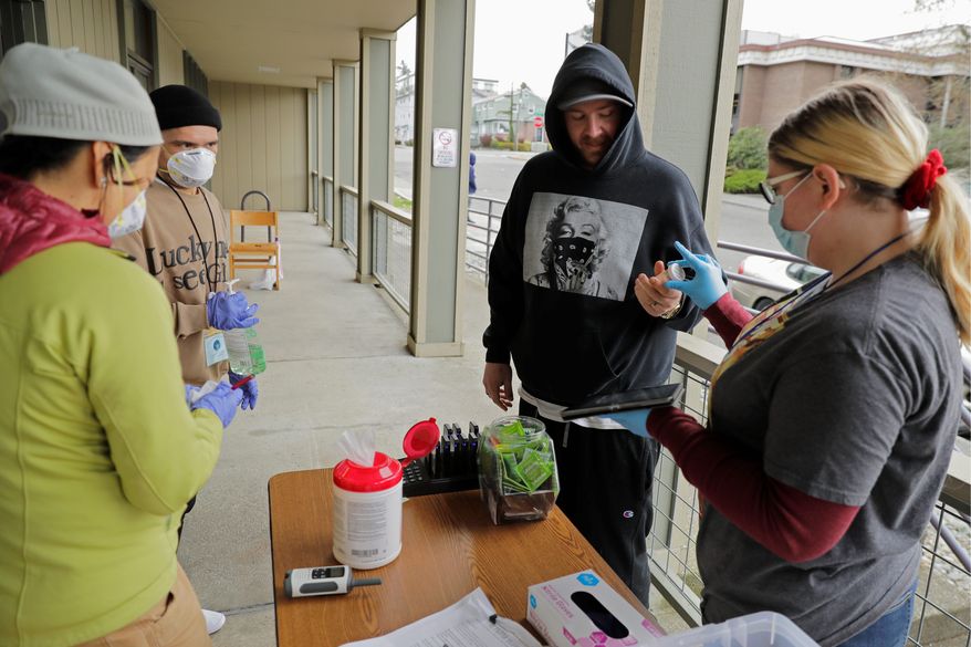A man picks up medication for opioid addiction at a clinic in Olympia, Washington, that is meeting patients outdoors and offering longer prescriptions in hopes of reducing the number of visits and the risk of infection due to the new coronavirus. (ASSOCIATED PRESS)