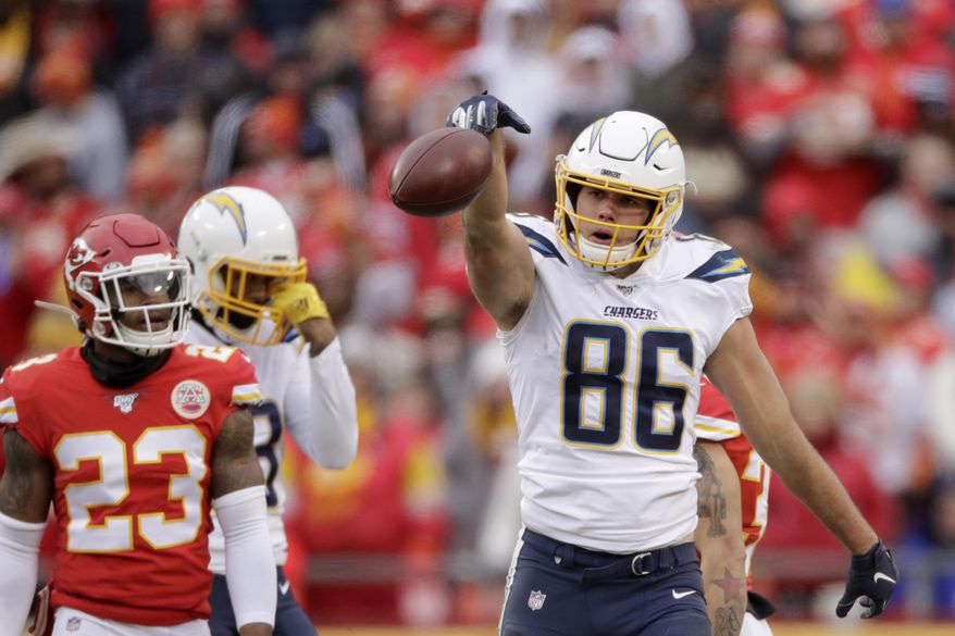 FILE - In this Dec. 29, 2019, file photo, Los Angeles Chargers tight end Hunter Henry (86) celebrates a catch as Kansas City Chiefs safety Armani Watts (23) watches during the second half of an NFL football game in Kansas City, Mo. Henry has signed his franchise tag with the Chargers, but the tight end remains optimistic that a long-term extension can still be reached. Henry said during a conference call on Wednesday, April 29, that both sides made progress before things were put on pause for draft preparations. (AP Photo/Charlie Riedel, File)