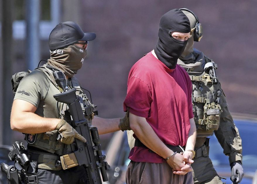 FILE -- In this Tuesday, July 2, 2019 photo the suspect Stephan E., center, is escorted to a helicopter in Karlsruhe, Germany. German prosecutors have charged far-right extremist with the killing last year of a regional politician Walter Luebcke from Chancellor Angela Merkel’s party and a near-fatal attack on an Iraqi asylum-seeker in 2016. (Uli Deck/dpa via AP, file)