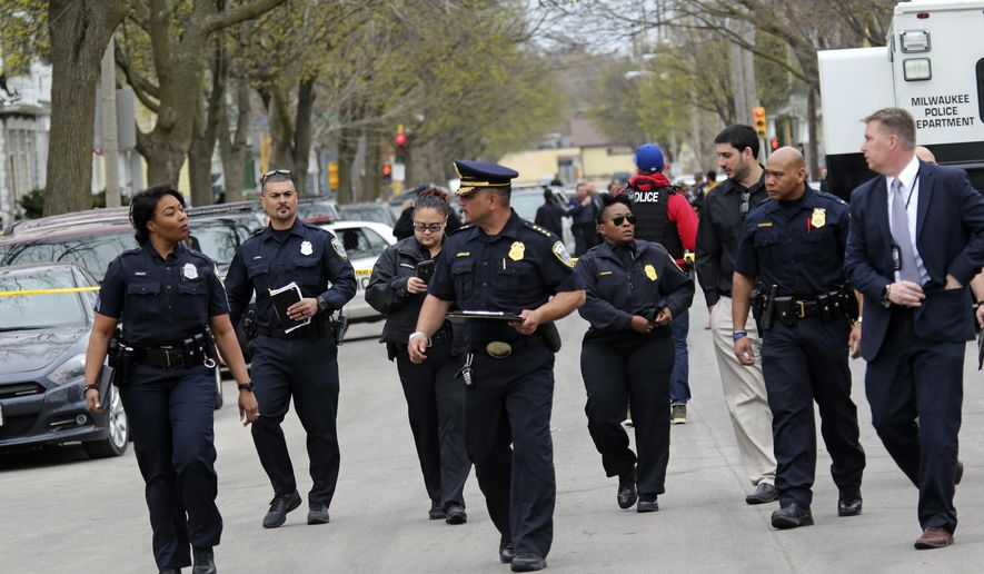 Milwaukee Police Chief Alfonso Morales, center, makes his way with his staff to give a news conference on the victims of a shooting where 5 people were killed Monday, April 27, 2020, at a home in Milwaukee, Wis., Monday, April 27, 2020.at the scene of a shooting where five people were killed in Milwaukee, Wis., Monday, April 27, 2020. Morales said his department received a call around 10:30 a.m. Monday from a man who said his family was dead. The man who called authorities to the house has been taken into custody, and detectives were trying to determine the relationship between the caller and the victims, Morales said. No names have been provided. (Angela Peterson/Milwaukee Journal-Sentinel via AP)