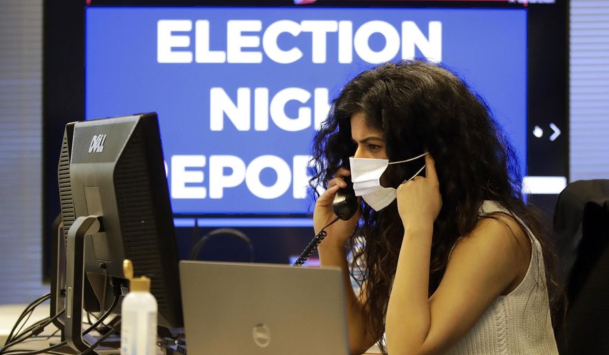 Ohio election official Parvinder Singh wears a mask while working in the election night reporting center in Columbus, Ohio, as returns begin to come in for the Ohio primary Tuesday, April 28, 2020. (AP Photo/Gene J. Puskar)