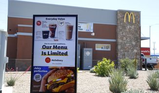 FILE - In this April 20, 2020 file photo, a new sign lets drive-thru customers know that the available menu at a local McDonalds is no longer complete due to the ongoing coronavirus restrictions in Phoenix. Most McDonald’s restaurants in the U.S. and China are now open for drive-thru and delivery, but global lockdown orders still took a bite out of the company’s first-quarter sales. McDonald’s said Thursday, April 30,  its sales fell 6% to $4.71 billion in the January-March period. (AP Photo/Ross D. Franklin, File)