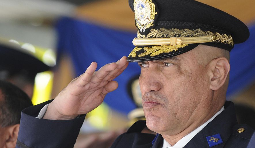 FILE - In this Dec. 21, 2012 file photo, Honduras Police Chief Gen. Juan Carlos Bonilla Valladares, also known as the Tiger, or "El Tigre," salutes during an event in Tegucigalpa, Honduras. The former chief of the Honduran National Police faces drug and weapons charges in New York, where prosecutors claimed on Thursday, April 30, 2020, that he traded his law enforcement clout to protect U.S.-bound shipments of cocaine. (AP Photo/File)