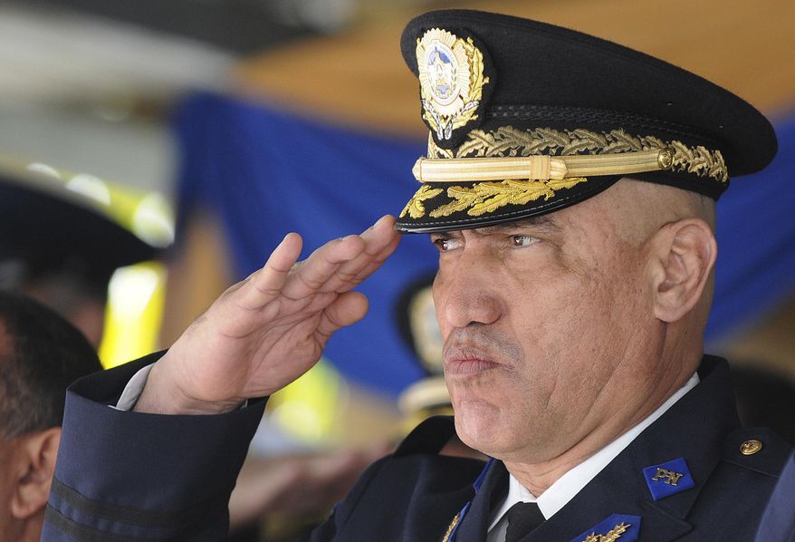 FILE - In this Dec. 21, 2012 file photo, Honduras Police Chief Gen. Juan Carlos Bonilla Valladares, also known as the Tiger, or "El Tigre," salutes during an event in Tegucigalpa, Honduras. The former chief of the Honduran National Police faces drug and weapons charges in New York, where prosecutors claimed on Thursday, April 30, 2020, that he traded his law enforcement clout to protect U.S.-bound shipments of cocaine. (AP Photo/File)