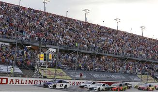 In this Sept. 2, 2018, file photo, Denny Hamlin (11) leads the pack to start the NASCAR Cup Series auto race at Darlington Raceway in Darlington, S.C. NASCAR will get its season back on track starting May 17 at Darlington Raceway in South Carolina without spectators, and the premier Cup Series plans to race four times in 10 days at a pair of iconic tracks. The revised schedule released Thursday, April 30, 2020, goes only through May and has a pair of Wednesday races — fulfilling fans longtime plea for midweek events. (AP Photo/Terry Renna, File)  **FILE**