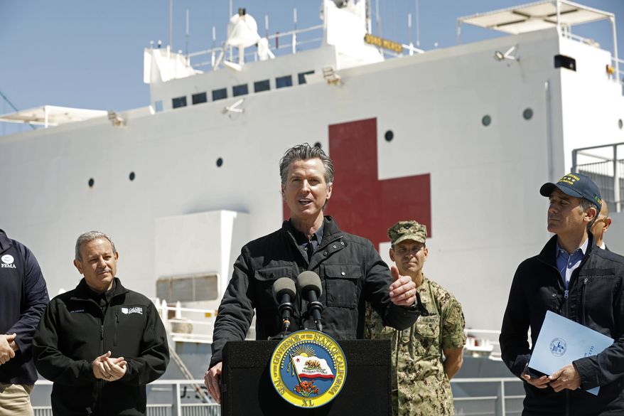 In this March 27, 2020, file photo California Governor Gavin Newsom, center, speaks next to Los Angeles Mayor Eric Garcetti, right, in front of the hospital ship USNS Mercy that arrived into the Port of Los Angeles. On May 1, 2020, the Pentagon announced the Mercy was no longer taking patients. (Carolyn Cole/Los Angeles Times via AP, Pool, File)