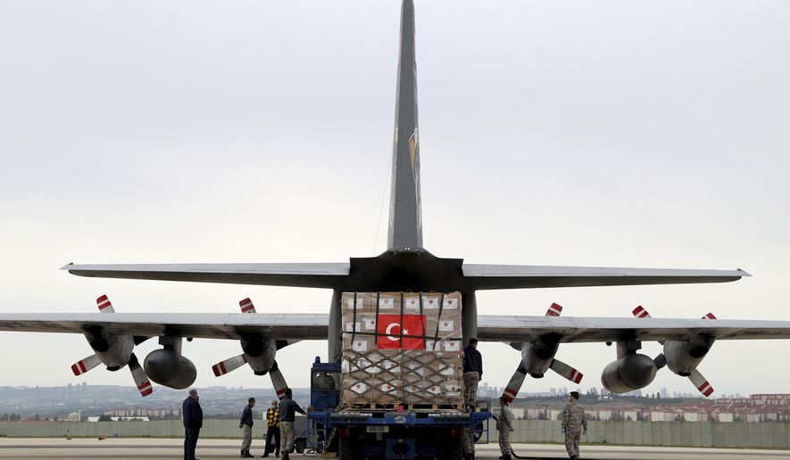 In this handout photo provided by the Turkish Defense Ministry, Turkish soldiers load a Turkish military cargo plane with Personal Protection Equipment donated by Turkey to help United States combat the new coronavirus outbreak, at the Etimesgut airport outside Ankara, Turkey, Thursday, April 30, 2020. Turkey is sending a second planeload of surgical masks, N95 masks and hazmat suits tor U.S. to help the country battle the coronavirus outbreak.(Turkish Defence Ministry via AP)