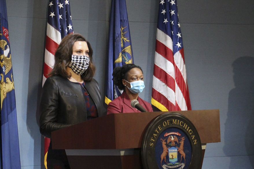 In a pool photo provided by the Michigan Office of the Governor, Michigan Gov. Gretchen Whitmer, wearing a mask, addresses the state during a speech in Lansing, Mich., Friday, May 1, 2020. The governor said Michigan&#39;s stay-at-home order remains in effect despite Republicans&#39; refusal to extend her underlying coronavirus emergency declaration, as she amended it to allow construction, real estate and outdoor work to resume next week. (Michigan Office of the Governor via AP, Pool)