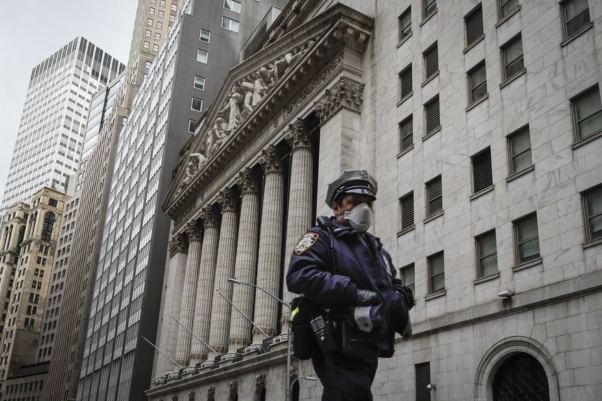 An NYPD officer walks along a sparsely populated Wall Street, Friday, May 1, 2020, in the Manhattan borough of New York. (AP Photo/John Minchillo) **FILE**