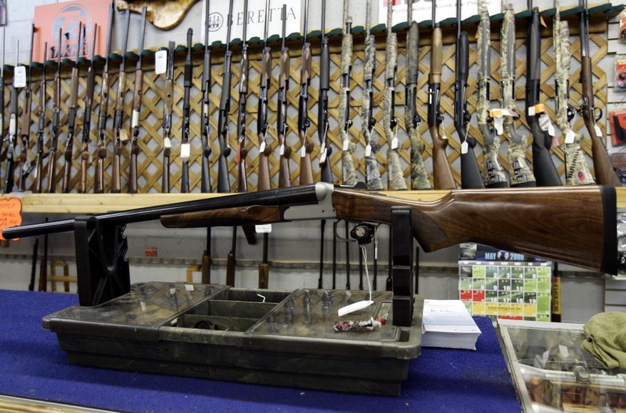 FILE - In a May 16, 2006 file photo, rifles line a hunting store&#39;s shelves in Ottawa. Prime Minister Justin Trudeau said Friday, May 1, 2020 that Canada is banning the use and trade of assault-style weapons immediately. (Jonathan Hayward/The Canadian Press via AP)