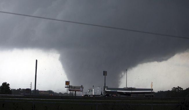 FILE - In this April 27, 2011, file photo, a tornado moves through Tuscaloosa, Ala. Despite the direst of warnings, the most skeptical among us didn’t fully believe it would be that bad. Reporters for The Tuscaloosa News worked hours on end to tell the stories of disaster, response and recovery from the 2011 tornado that tore a 5.9-mile path across Tuscaloosa, damaging or destroying more than 12 percent of the city along the way. (Dusty Compton/The Tuscaloosa News via AP, File)