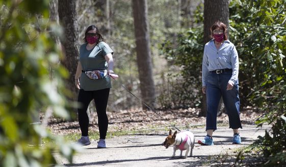 People wearing a protective face coverings hike at Shark River Park in Wall Township, N.J., Saturday, May 2, 2020. Parks and golf courses reopened Saturday after being closed to to the coronavirus pandemic. (AP Photo/Matt Rourke)
