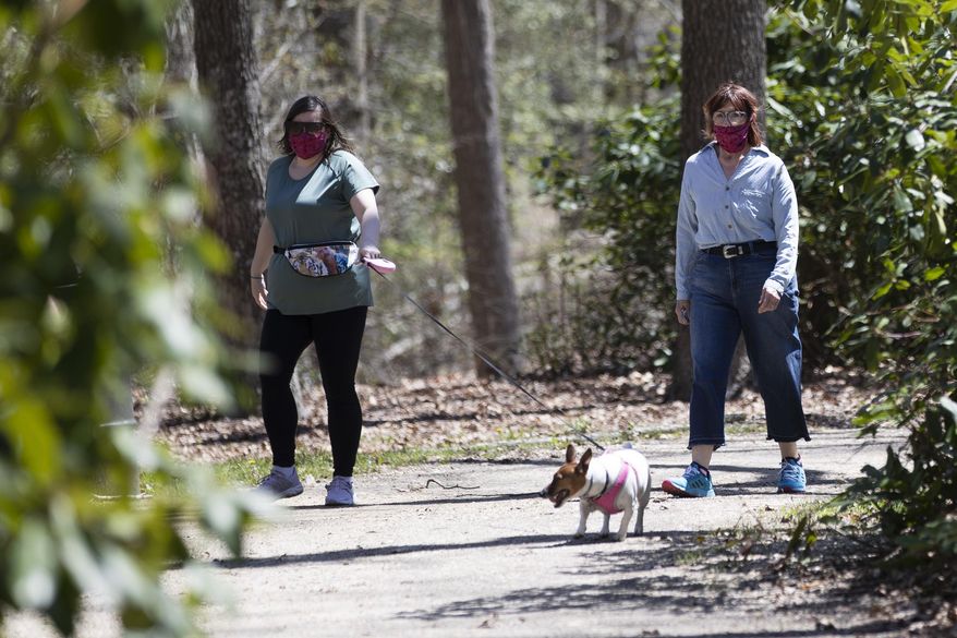 People wearing a protective face coverings hike at Shark River Park in Wall Township, N.J., Saturday, May 2, 2020. Parks and golf courses reopened Saturday after being closed to to the coronavirus pandemic. (AP Photo/Matt Rourke)