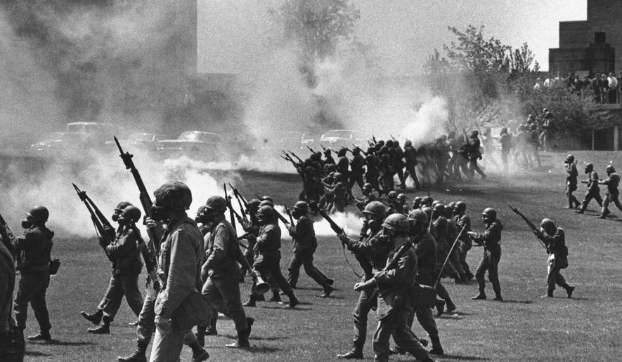 FILE - In this May 4, 1970 file photo, Ohio National Guard soldiers move in on war protestors at Kent State University in Kent, Ohio. Four persons were killed and multiple people were wounded when National Guardsmen opened fire. The school, about 30 miles southeast of downtown Cleveland, had planned an elaborate multi-day commemoration for the 50th anniversary Monday, May 4, 2020. The events were canceled because of social distancing restrictions amid the coronavirus pandemic. Some events, activities and resources are being made available online. (AP Photo, File)