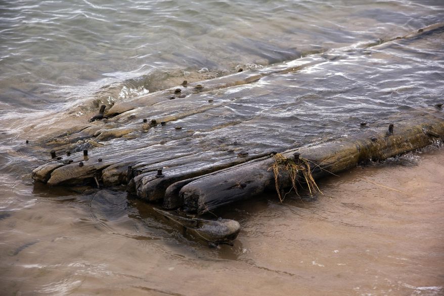 In a photo from April 27, 2020, a relic washes up on shore near Ludington State Park in Ludington, Mich. When conditions are favorable, certain relics of a bygone era emerge from the sand. Several locals walking on the beach spotted the fragment of a shipwreck and promptly called the Michigan Shipwreck Research Association, according to Valerie van Heest, a board director of the MSRA. The MSRA is a non-profit organization that researches, explores, documents and interprets shipwrecks in Michigan. (Steve Begnoche Photography/Ludington Daily News via AP)