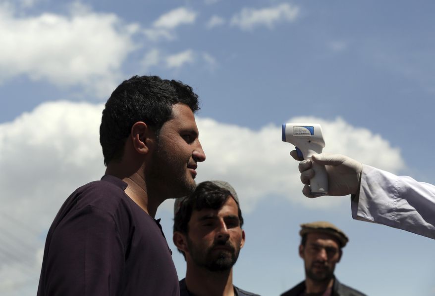 A health worker checks the temperature of car passengers in an effort to help stop the spread of the coronavirus, as they enter the city in the Paghman district of Kabul, Afghanistan, Sunday, May 3, 2020. (AP Photo/Rahmat Gul)