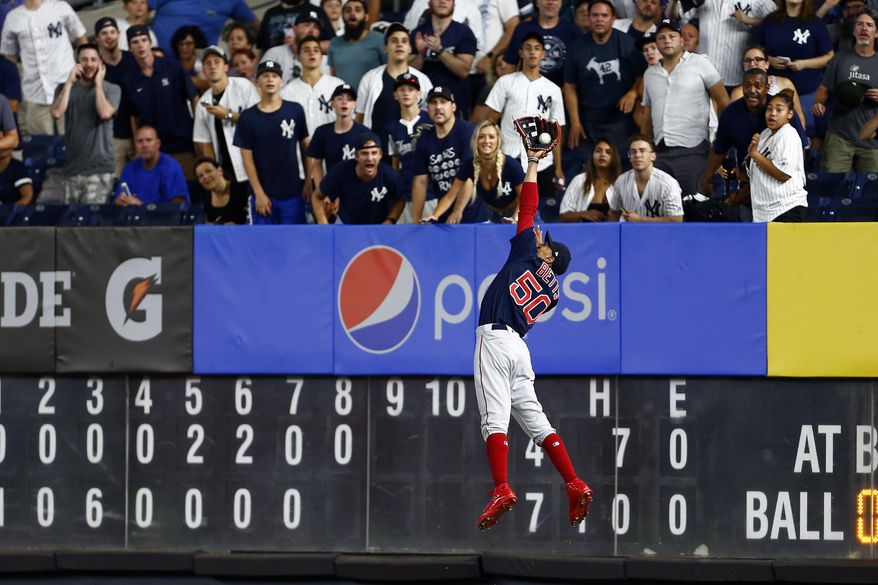 In this Sunday, Aug. 4, 2019, file photo, Boston Red Sox right fielder Mookie Betts makes a leaping catch on a ball hit by New York Yankees' DJ LeMahieu during the eighth inning of a baseball game in New York. With the sports calendar still mostly on hold because of the coronavirus pandemic, The Associated Press takes a look at some of the live sporting events that would have taken place the week of May 4-10, 2020, including the season's first meeting between the Red Sox and Yankees, in The Bronx. (AP Photo/Adam Hunger, File) **FILE**