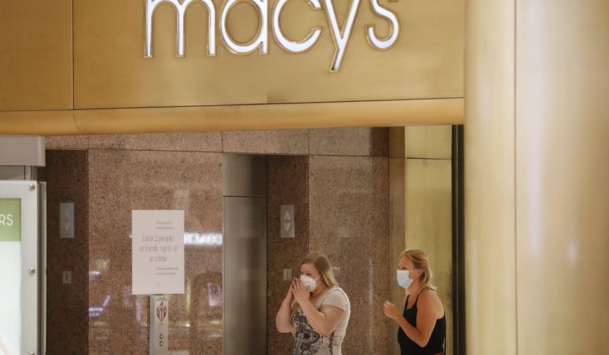 Amid concerns of the spread of COVID-19, shoppers wear masks while walking past a Macy's store at the Galleria Dallas mall in Dallas, Monday, May 4, 2020. (AP Photo/LM Otero)